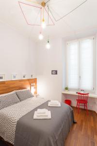 ein weißes Schlafzimmer mit einem Bett und einem roten Stuhl in der Unterkunft The Best Rent - Apartment near Porta Romana in Mailand