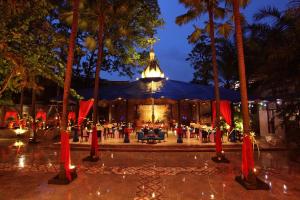 a wedding venue with palm trees in front of a building at Hotel Tugu Malang - CHSE Certified in Malang