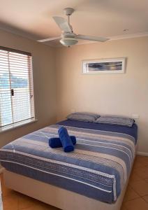 a bedroom with a bed with a blue pillow on it at Outback Oasis Caravan Park in Carnarvon