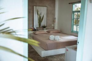 a bedroom with a bed with two towels on it at Indie Beach Koh Chang in Ko Chang