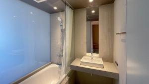 a bathroom with a shower and a sink and a tub at kamakura seizan in Kamakura