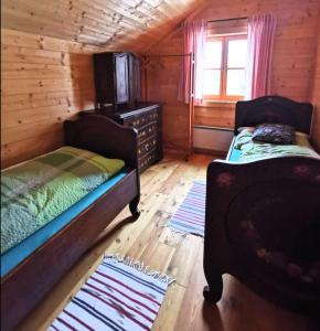 a bedroom with two beds in a log cabin at Marhütte in Ebene Reichenau