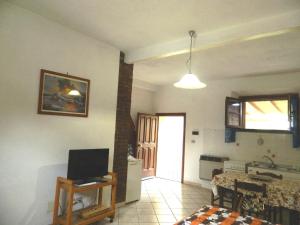 een woonkamer met een televisie en een keuken bij Podere Santo Signoretto in San Vincenzo