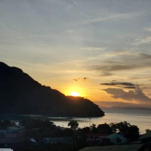 a sunset over a body of water with a mountain at Blue View House Phi Phi in Phi Phi Don