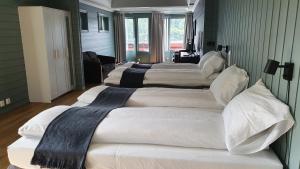 um grupo de quatro camas num quarto em Villa Oleanna em Lysekloster