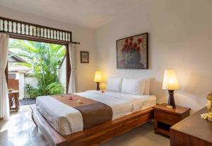 a bedroom with a large bed and a large window at Alam Anda Ocean Front Resort & Spa CHSE Certified in Tejakula