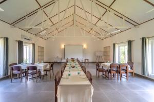 a large room with tables and chairs and a white ceiling at Neer Ganga Resorts in Rishīkesh