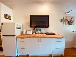 uma cozinha com um frigorífico branco e um balcão em RAMADA RESORT - Stylish Hotel Studio Apartment em Port Douglas