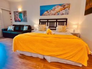 een groot geel bed in een kamer met een bank bij RAMADA RESORT - Stylish Hotel Studio Apartment in Port Douglas