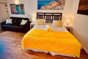 um quarto com uma cama grande e um cobertor amarelo em RAMADA RESORT - Stylish Hotel Studio Apartment em Port Douglas