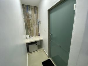 een badkamer met een douche en een glazen deur bij Corrie Chalet Langkawi in Pantai Cenang
