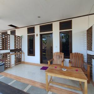 吉利特拉旺安Putra Boyan Cottages的客厅配有两把椅子和一张木桌