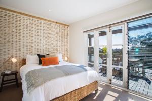 a bedroom with a bed and a large window at The Deck Tideways in Sorrento
