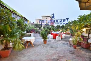 a courtyard with white tables and plants and a building at Tekareesinn in Lucknow