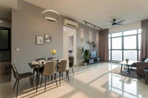 a dining room and living room with a table and chairs at Conezion Residence Putrajaya 3BR6Pax IOI City Mall in Putrajaya