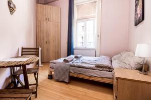 een slaapkamer met een bed, een bureau en een raam bij Aurora Apartments in Boedapest