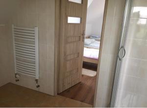 a bathroom with a shower and a door to a bedroom at Siedlisko u Agi in Ryn
