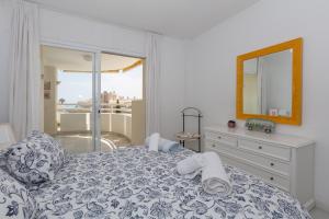 a bedroom with a bed with a dresser and a mirror at Carihuela beach in Torremolinos +19 photos
