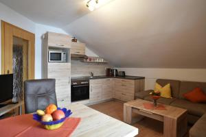 a living room with a couch and a table with a bowl of fruit at Ferienwohnungen Haus Rachel in Neuschönau