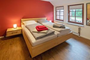 een slaapkamer met een groot bed en een rode deken bij Gulfhof Alt-Addenhausen in Neuharlingersiel