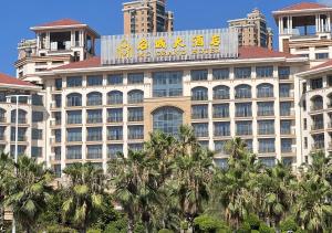 un grand bâtiment avec un panneau en haut dans l'établissement Ming Cheng Hotel Fuzhou, à Fuzhou