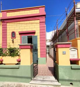 un bâtiment coloré avec une porte dans une rue dans l'établissement Casa Fadea, à Gagliano del Capo