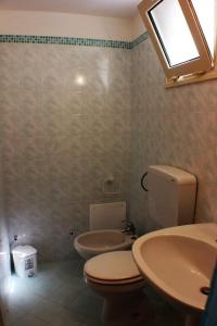 La salle de bains est pourvue de toilettes, d'un lavabo et d'un miroir. dans l'établissement Casa Fadea, à Gagliano del Capo