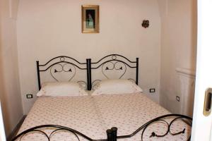a bedroom with a black bed with two white pillows at Casa Fadea in Gagliano del Capo
