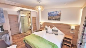 a bedroom with a white bed and a mirror at Heimat Apartments - Zillertal in Gerlos