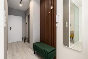 un pasillo con un banco verde y un espejo en Apartamenty Prestige Centrum, en Bielsko-Biala