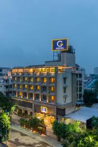 a hotel with a sign on top of it at HOTEL G EXPRESS Formerly Known as TGB Express in Ahmedabad
