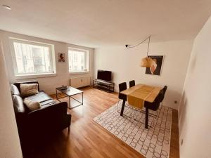 ein Wohnzimmer mit einem Tisch und einem Sofa in der Unterkunft Apartment in the heart of Aalborg in Aalborg
