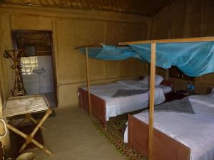 a bedroom with two bunk beds and a mirror at Bardia Eco Lodge in Bardiyā