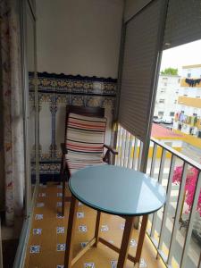 un tavolo e una sedia sul balcone di Apartamento grumete a El Puerto de Santa María