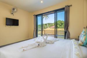 sypialnia z łóżkiem i dużym oknem w obiekcie New Heaven Dive Resort w Ko Tao