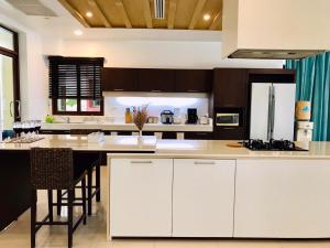 a kitchen with white cabinets and a large island at Amatapura Beachfront Villa 14, SHA Certified in Ao Nam Mao