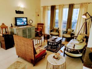 a living room filled with furniture and a tv at Luxurious Affordable Serviced Apt PariChowk/ExpoMart/Expressway Noida in Greater Noida