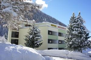 a hotel resort building with snow in front of it at Hotel Astoria in Leukerbad
