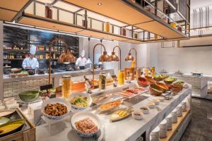 a buffet line with many different types of food at Novotel Shanghai Caohejing in Shanghai