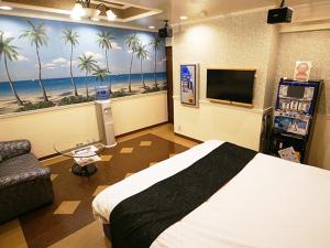 a bedroom with a bed and a tv and palm trees at メルヘンの森パート2大人専用 in Yoshioka