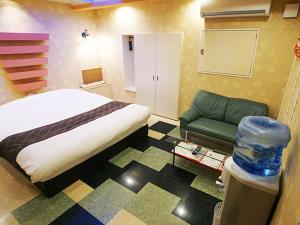 Yoshioka的住宿－メルヘンの森パート2大人専用，一间卧室配有一张床和一张绿色沙发