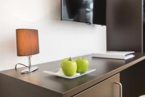 two green apples on a plate on a counter with a lamp at Gästezimmer by Jöchlinger in Gerasdorf bei Wien