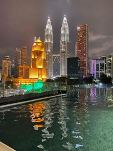 uma vista para o horizonte da cidade à noite com uma piscina em Legasi Kampung Baru by Twenty7 em Kuala Lumpur