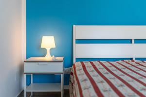 um quarto com uma cama e uma mesa de cabeceira com um candeeiro em Villetta a mare Licata em Licata