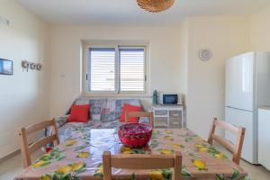 uma cozinha e sala de jantar com uma mesa e um frigorífico em Villetta a mare Licata em Licata