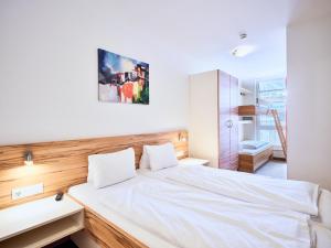 a bedroom with a white bed and a sink at Grafenberg Resort by Alpeffect Hotels in Wagrain