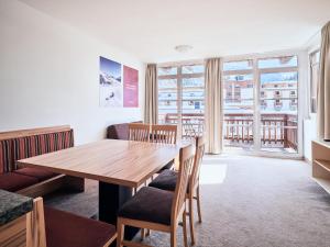 comedor con mesa de madera y sillas en Grafenberg Resort by Alpeffect Hotels, en Wagrain