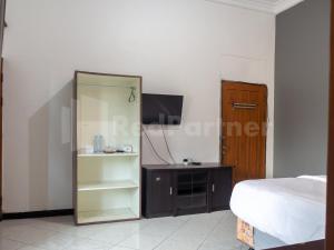 um quarto com uma cama, uma cómoda e um espelho em Tjahaja Baroe Syariah Mitra RedDoorz At Dukuh Kupang em Surabaya