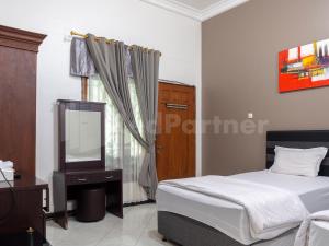 um quarto com uma cama, uma cómoda e um espelho em Tjahaja Baroe Syariah Mitra RedDoorz At Dukuh Kupang em Surabaya