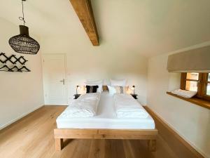 a bedroom with a bed with white sheets and pillows at Natur pur - Doppelhaushälfte im idyllischen Kreuth in Kreuth